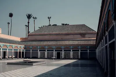 a large building with palm trees in the background at Magnifique appartement Marrakech in Marrakech