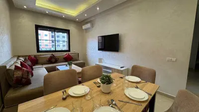 a living room with a table and a couch at Magnifique appartement Marrakech in Marrakech