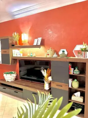 a kitchen with an orange wall and a counter with a microwave at Appartement Marrakech Hivernage N54 RESIDENCE CAPRICE PALACE in Marrakech