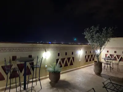 a patio with tables and chairs at night at Le riad de Salima, Noor Es Saadi design in Marrakech