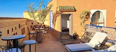 a balcony with tables and chairs on a building at Le riad de Salima, Noor Es Saadi design in Marrakech