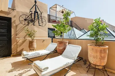 a balcony with two chairs and a bike on the wall at Riad l'Empire in Marrakech