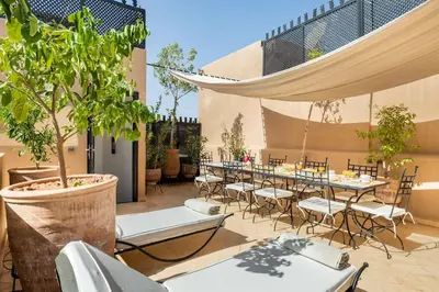 a patio with a long table and chairs at Riad l'Empire in Marrakech