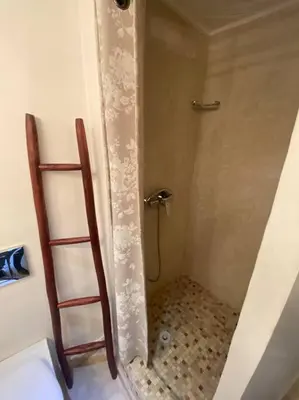 a bathroom with a shower with a ladder in it at Bel appartement en centre-ville avec piscine in Marrakech