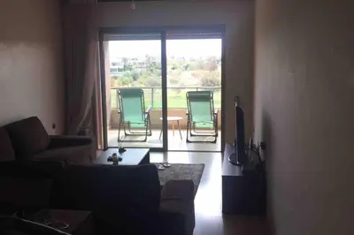 a living room with chairs and a large window at BEL APPART FONCTIONNEL PRESTIGIA GOLF MARRAKECH in Marrakech
