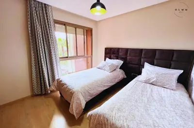 a bedroom with two beds and a window at Luxurious Stay at Prestigia Golf Marrakech with Golf Course, Pool, and Breathtaking Atlas Mountains View in Marrakech