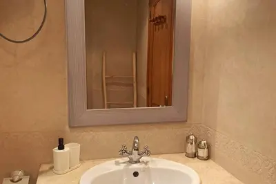 a bathroom sink with a mirror and a chair in it at Sunny terrace & comfy beds in Marrakech in Marrakech