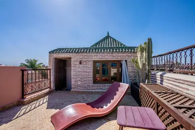 a balcony with a bench and a building at Riad Dombaraka in Marrakech