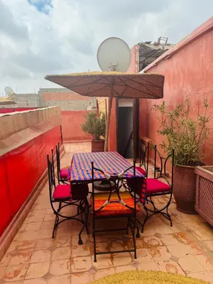 a table and chairs with an umbrella on a patio at RIAD ALGHANI in Marrakech