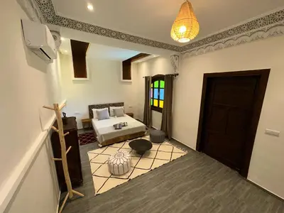 a bedroom with a bed and a door in a room at Oasis Merasi Marrakech in Marrakech