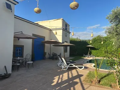a patio with chairs and umbrellas and a pool at Oasis Merasi Marrakech in Marrakech