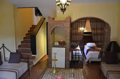 a living room with a staircase and a bedroom at GREEN HOUSE in Marrakech