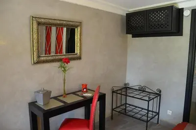a dining room with a table and a vase with a flower on it at GREEN HOUSE in Marrakech