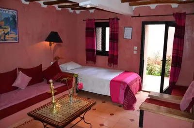 a bedroom with a bed and a couch and a window at GREEN HOUSE in Marrakech