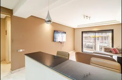 a living room with a kitchen and a couch at stylish appartment heart of gueliz in Marrakech