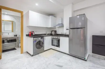 a kitchen with a stainless steel refrigerator and a dishwasher at NEW! Chic Plein Gueliz, parking, Iptv in Marrakech