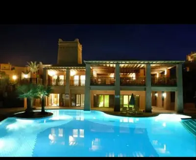 a large pool in front of a building at night at Villa Agdal in Marrakech