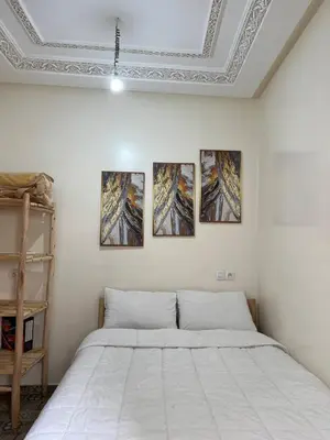 a bedroom with a bed with four paintings on the wall at Cosy Appart private riad jemaa el fna in Marrakech
