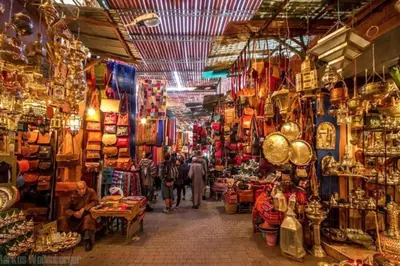 a market with people walking through a market with shops at Cosy Appart private riad jemaa el fna in Marrakech