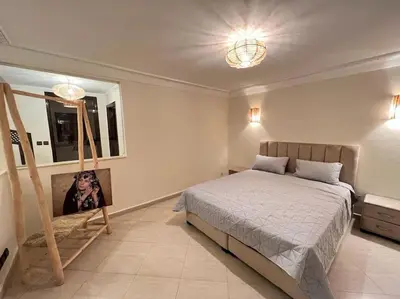 a bedroom with a bed and a chair in it at The Majestic Marrakesh Duplex in Marrakech