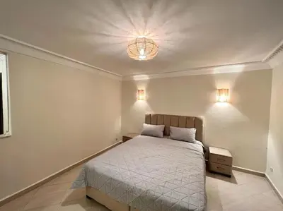 a bedroom with a bed and a light on the ceiling at The Majestic Marrakesh Duplex in Marrakech