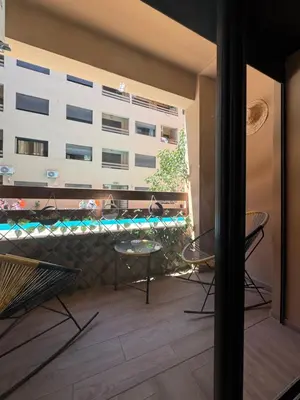 a balcony with a table and chairs and a building at Glorieux appartement à gueliz in Marrakech