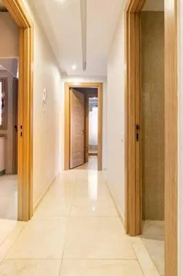 an empty hallway with doors and a tile floor at Magnifique appartement Les perles de marrakech lux avec 2 piscines in Marrakech