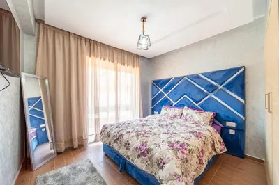 a bedroom with a large bed with a blue headboard at Résidence Coralia les orangers in Marrakech