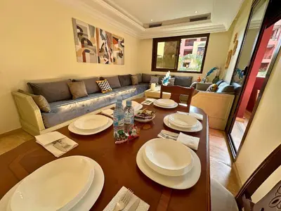 a living room with a table and a couch at Appartement calme, Guéliz in Marrakech