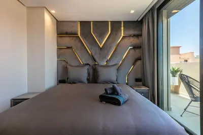 a bedroom with a large bed with a wooden headboard at Duplex de Luxe Victor Hugo Gueliz in Marrakech