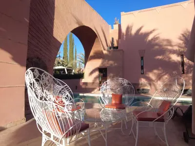 a glass table and chairs on a patio at Superbe villa avec piscine privée - Golf Amelkis in Marrakech