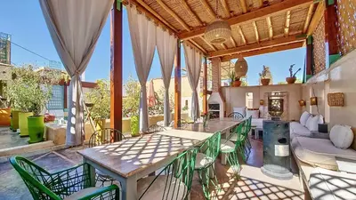 an outdoor patio with a table and chairs at Riad Chambres D'Amis Marrakech in Marrakech