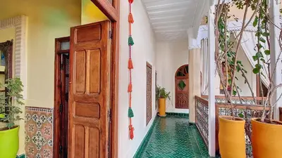a hallway with a door and a green tile floor at Riad Chambres D'Amis Marrakech in Marrakech