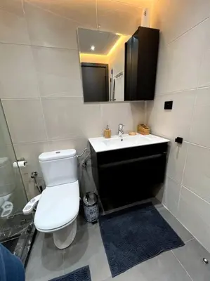 a bathroom with a white toilet and a sink at Appartement Bagatelle in Marrakech