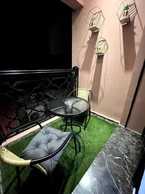 a patio with a table and chairs on a balcony at Appartement Bagatelle in Marrakech