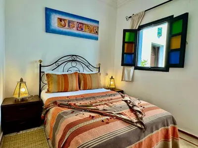 a bedroom with a bed and a window at Riad Iklil in Marrakech