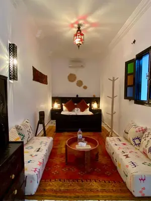 a living room with a couch and a bed at Riad Iklil in Marrakech