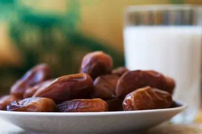 a bowl of nuts on a plate with a glass of milk at Rita House - Le Petit Paradis sur Terre in Douar Caïd Layadi