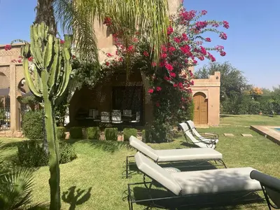 a garden with two lounge chairs and a cactus at Rita House - Le Petit Paradis sur Terre in Douar Caïd Layadi