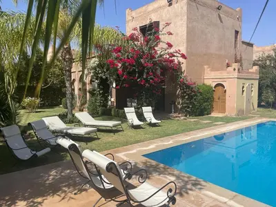 a swimming pool with lounge chairs and a house at Rita House - Le Petit Paradis sur Terre in Douar Caïd Layadi