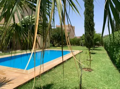 a swimming pool in a yard next to a house at Rita House - Le Petit Paradis sur Terre in Douar Caïd Layadi