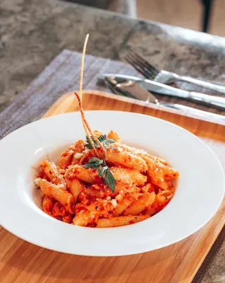 a white plate of food with pasta on a table at Villa Warhol Marrakech in Marrakech