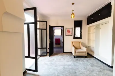 a hallway with a chair and a room with a bed at Villa Warhol Marrakech in Marrakech