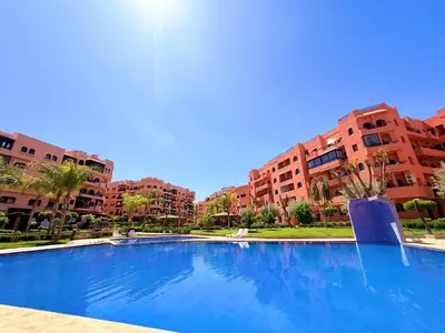 a large blue swimming pool in front of some buildings at Appartement Marrakech With Pool and View in Marrakech
