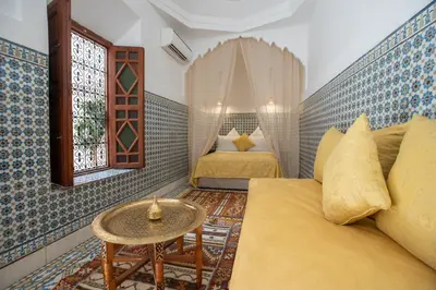 a small room with two beds and a table at Riad Albaraka in Marrakech
