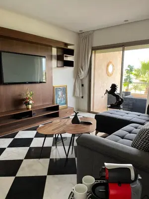 a living room with a couch and a tv at Appt Premium 3 rooms with big terrace at Prestigia Marrakech in Marrakech