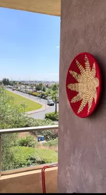 a red and gold sign on the side of a building at Appt Premium 3 rooms with big terrace at Prestigia Marrakech in Marrakech