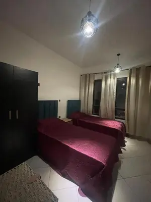 a bedroom with two beds with red sheets at Appartement véranda marrakech in Marrakech