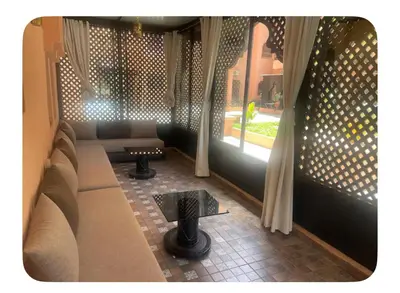 a room with a couch and a table and a window at Appartement véranda marrakech in Marrakech