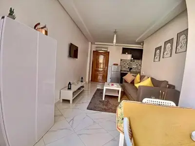 a living room with a couch and a table at appartement center de Guéliz avec piscine in Marrakech